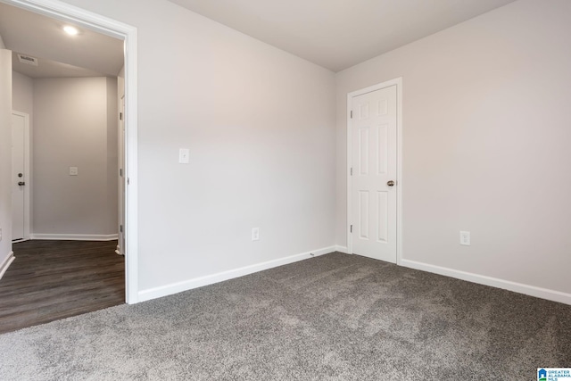 spare room with dark carpet