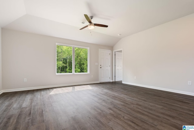 spare room featuring dark hardwood / wood-style floors, vaulted ceiling, and ceiling fan