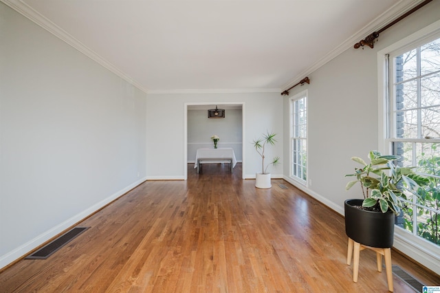 empty room with hardwood / wood-style flooring and crown molding