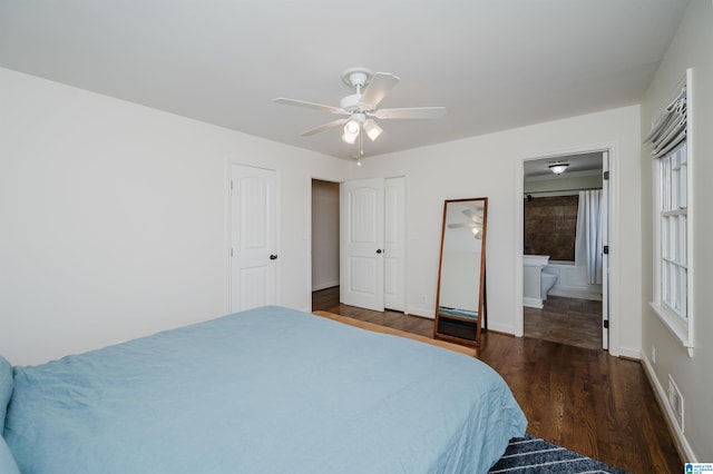 bedroom featuring ceiling fan, dark wood-type flooring, and ensuite bath