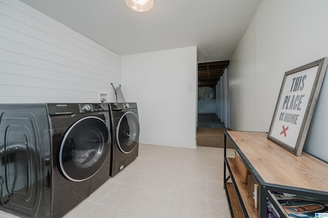 clothes washing area featuring washer and dryer and wood walls