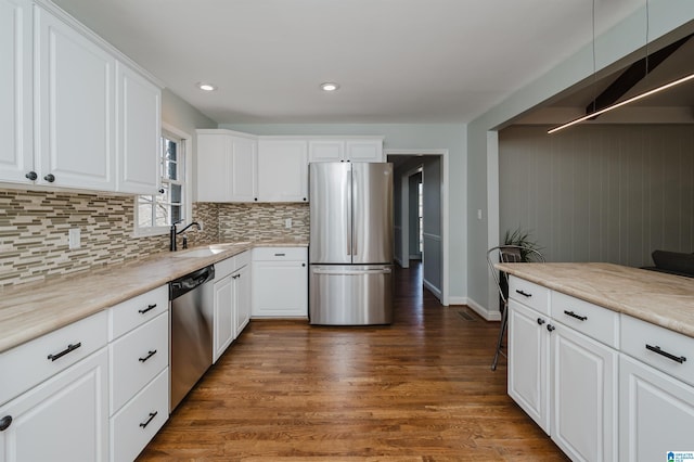 kitchen featuring appliances with stainless steel finishes, sink, dark wood-type flooring, and white cabinets