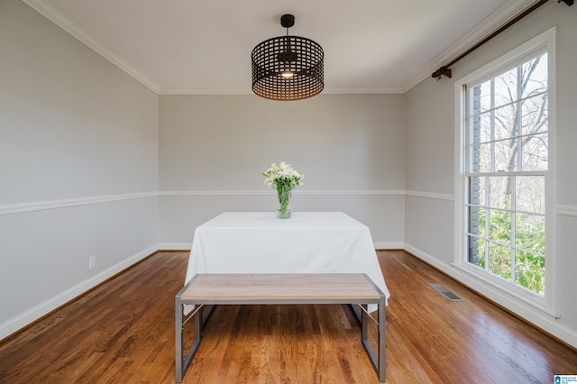 dining area with hardwood / wood-style flooring, a healthy amount of sunlight, and ornamental molding