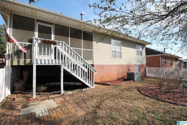 rear view of property with central AC and a sunroom