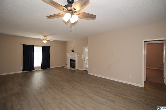 unfurnished living room with dark wood-type flooring, a textured ceiling, and ceiling fan