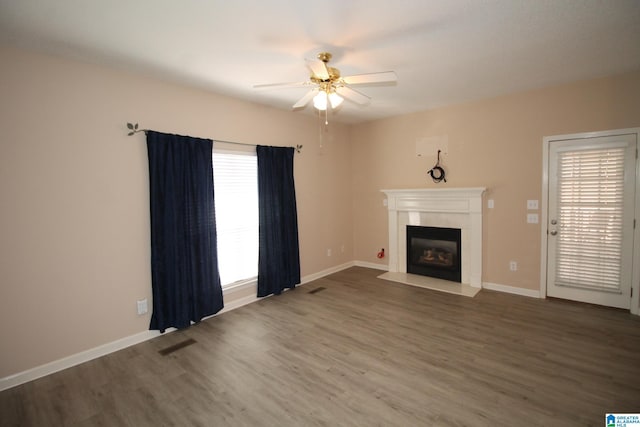 unfurnished living room featuring hardwood / wood-style flooring, ceiling fan, and a healthy amount of sunlight