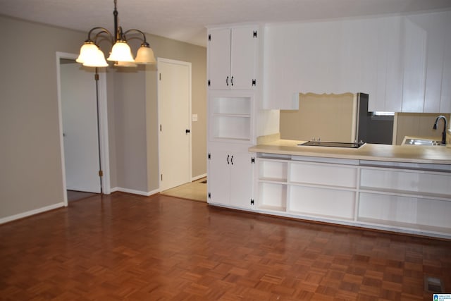 kitchen featuring dark parquet flooring, white cabinetry, an inviting chandelier, sink, and hanging light fixtures