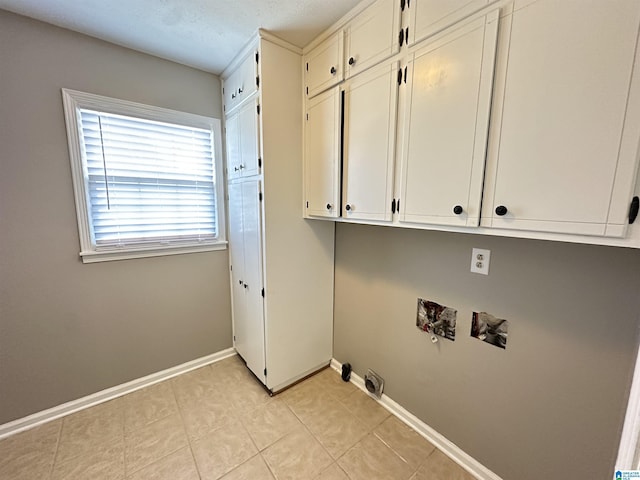 laundry room featuring hookup for a washing machine, cabinets, and light tile patterned flooring