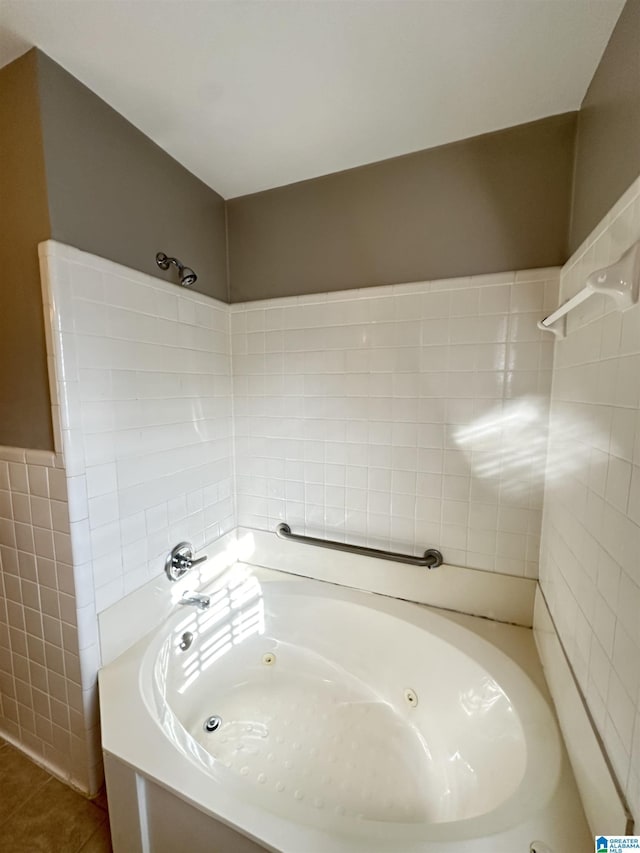 bathroom featuring a tub to relax in, tile patterned flooring, and tile walls