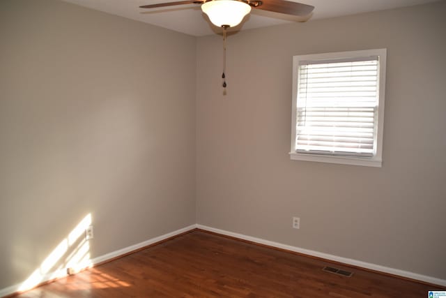 empty room with ceiling fan and dark wood-type flooring