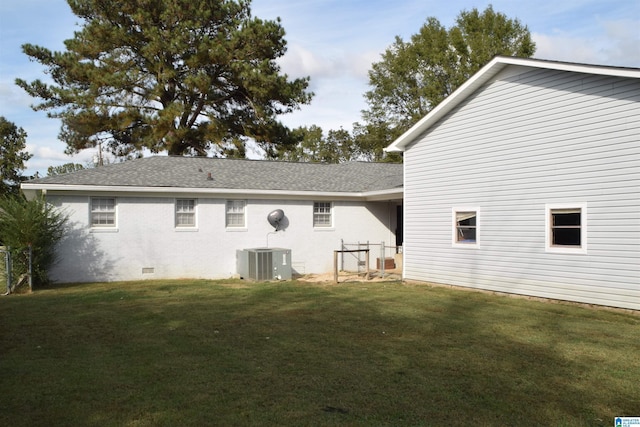 rear view of property featuring central AC and a yard