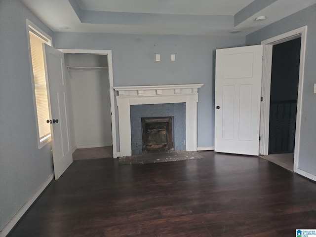 unfurnished living room featuring dark hardwood / wood-style floors and a raised ceiling