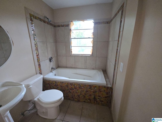 bathroom featuring sink, tiled tub, toilet, and tile patterned flooring