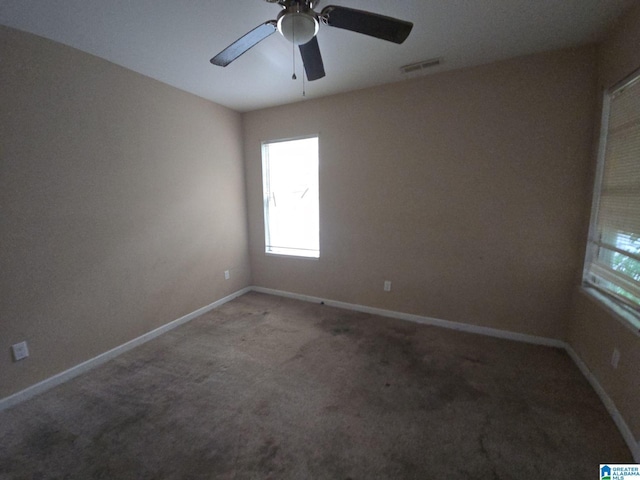 carpeted spare room with ceiling fan