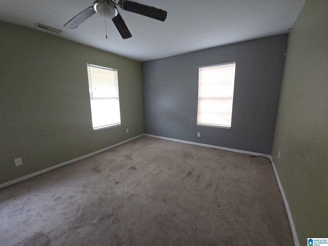 carpeted spare room featuring ceiling fan