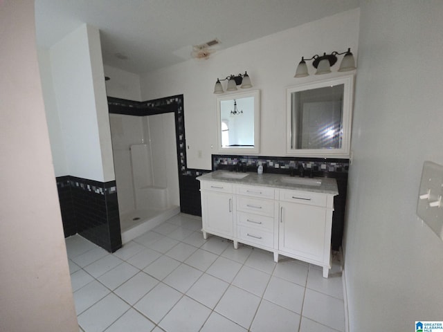 bathroom with vanity, walk in shower, tile patterned floors, and tasteful backsplash