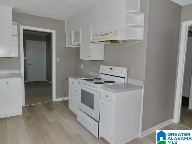 kitchen featuring white range with electric stovetop, white cabinetry, light hardwood / wood-style floors, and a textured ceiling