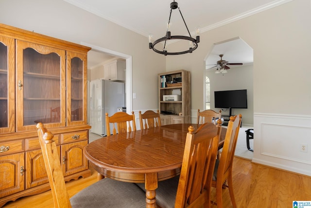 dining space featuring ornamental molding, ceiling fan, and light hardwood / wood-style floors