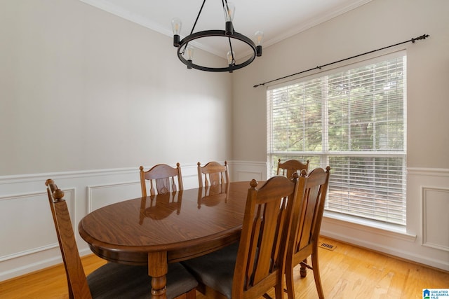 dining room featuring ornamental molding, a chandelier, and light wood-type flooring