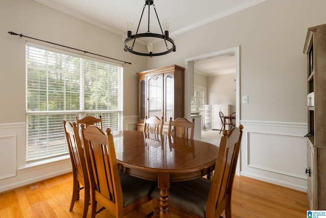 dining room with ornamental molding and light hardwood / wood-style floors