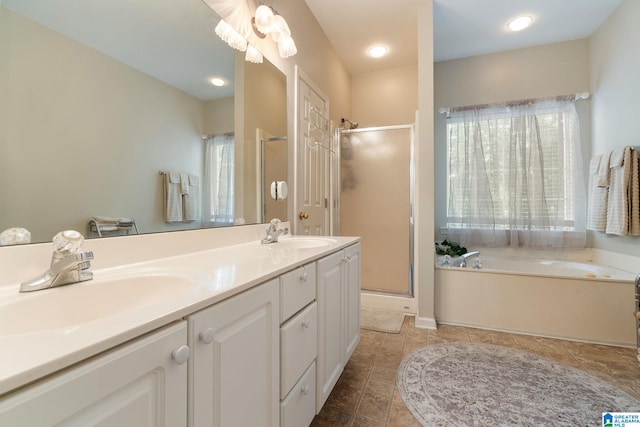 bathroom featuring a healthy amount of sunlight, independent shower and bath, tile patterned flooring, and vanity