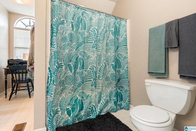 bathroom featuring toilet, tile patterned flooring, and a shower with shower curtain