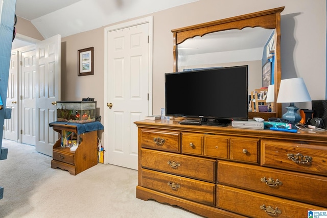 bedroom featuring lofted ceiling and light carpet