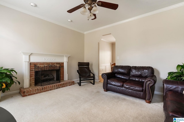 living room with a brick fireplace, crown molding, and carpet floors