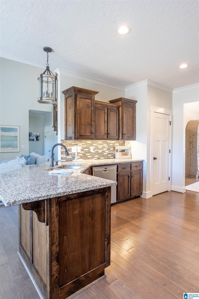 kitchen featuring light stone countertops, decorative backsplash, sink, dark hardwood / wood-style floors, and stainless steel dishwasher