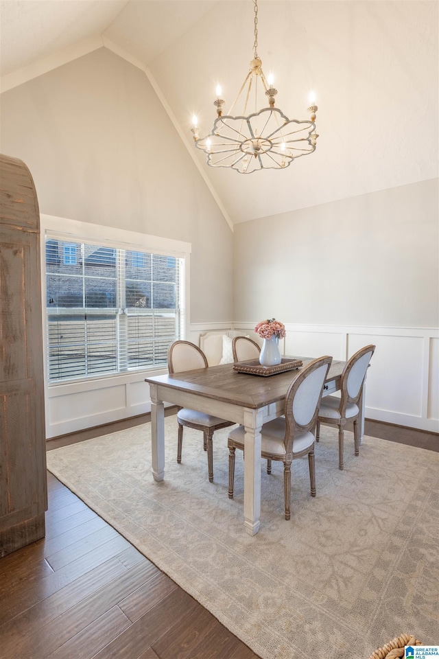 dining space featuring a notable chandelier, hardwood / wood-style floors, and lofted ceiling