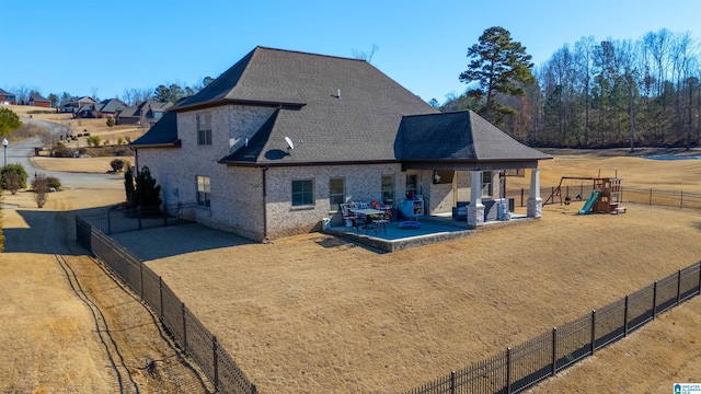 back of house with a patio area and a playground