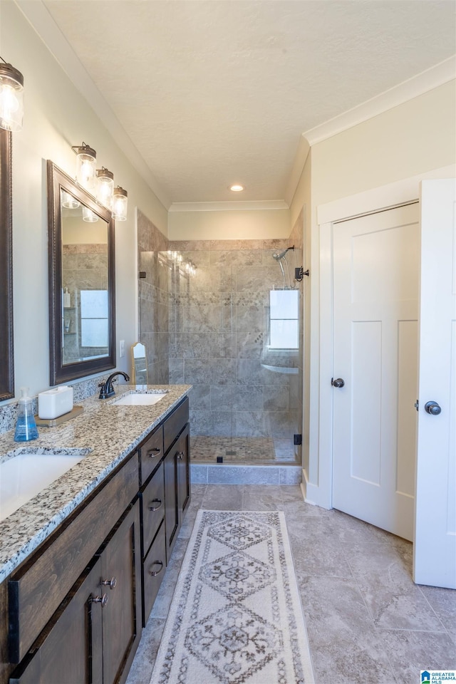 bathroom featuring crown molding, vanity, and a tile shower