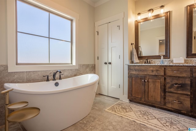 bathroom with vanity, a tub, tile patterned floors, and plenty of natural light