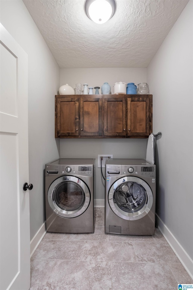 washroom with a textured ceiling, cabinets, and independent washer and dryer