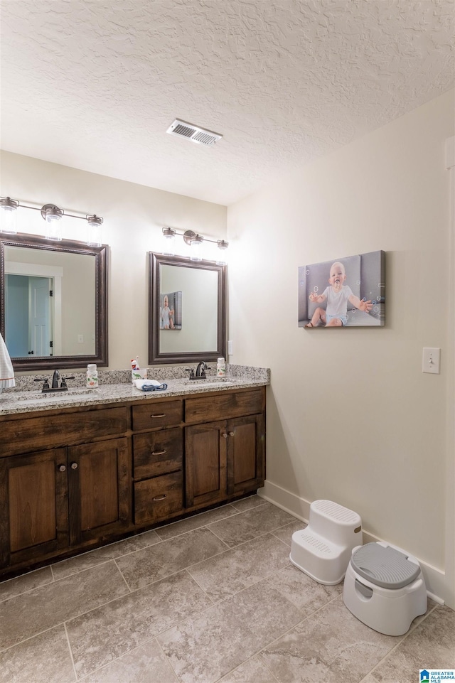 bathroom with a textured ceiling and vanity