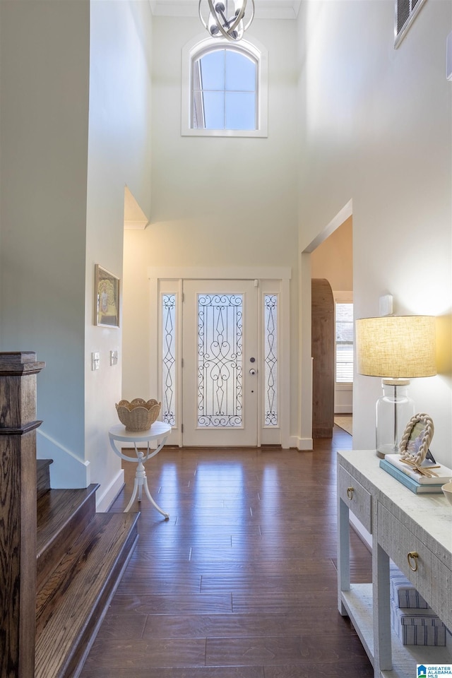 entryway with a notable chandelier, a high ceiling, and dark wood-type flooring