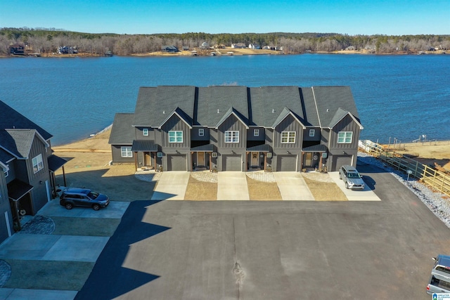 view of front of property featuring an attached garage, board and batten siding, driveway, and a water view