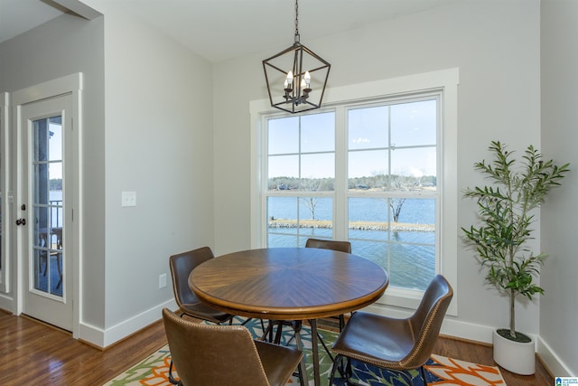 dining room featuring a water view, dark hardwood / wood-style floors, and a chandelier