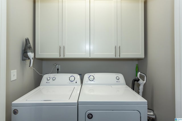 washroom with cabinets and washing machine and clothes dryer