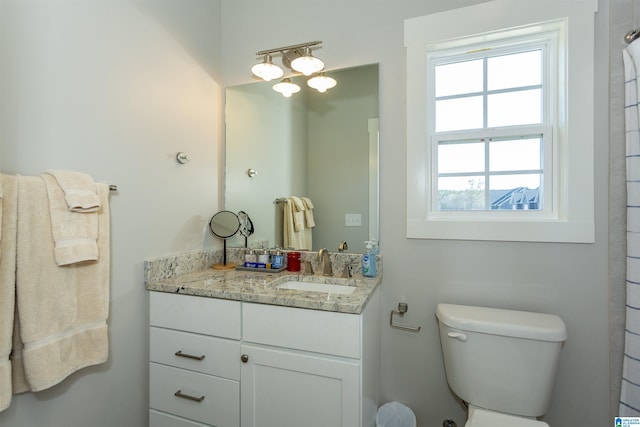 bathroom featuring vanity, plenty of natural light, and toilet