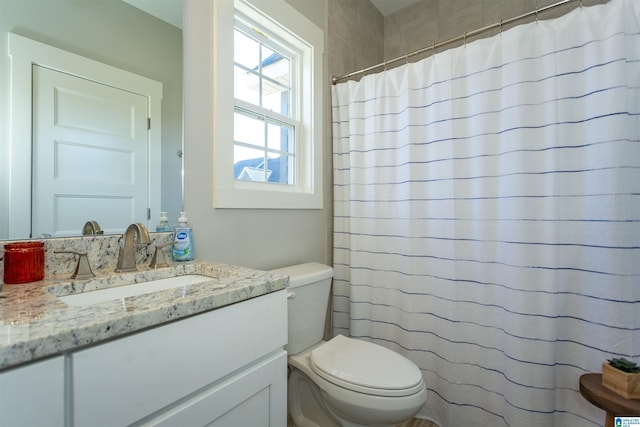 bathroom with vanity, toilet, and curtained shower