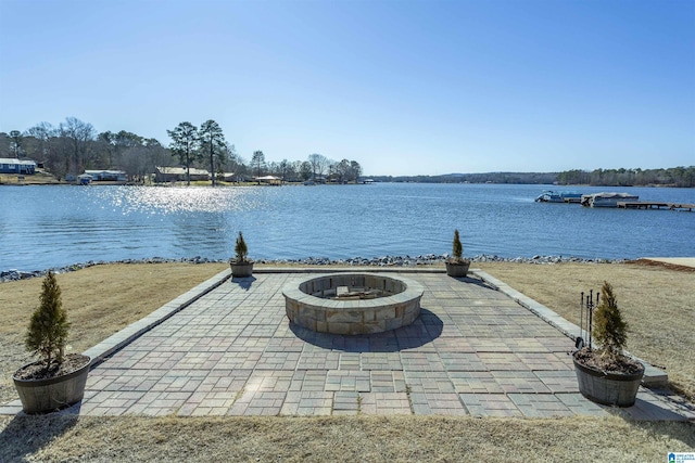 exterior space with a water view, an outdoor fire pit, and a patio area