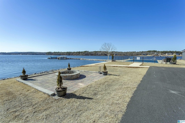 exterior space featuring a water view and an outdoor fire pit