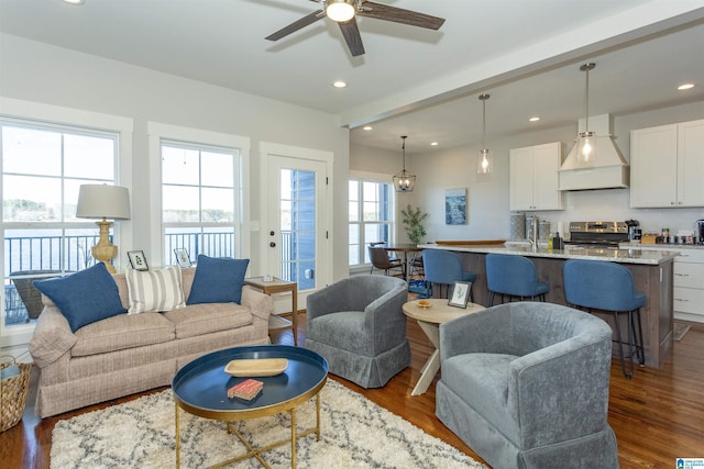 living room with dark wood-type flooring and ceiling fan