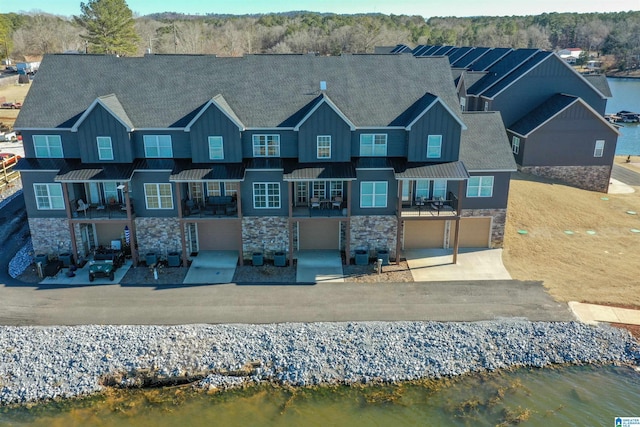 back of house featuring a garage and a water view