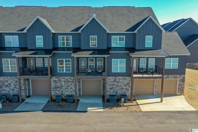 view of front of home featuring a balcony and central air condition unit