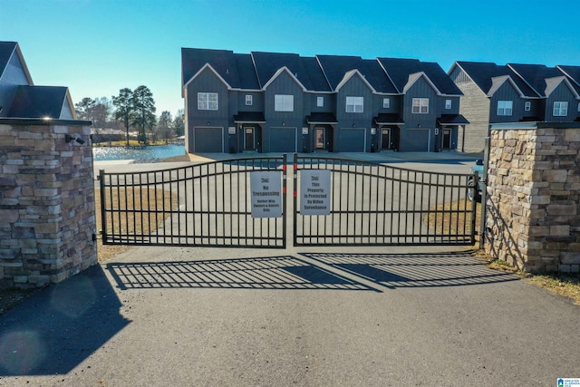 view of gate featuring a garage and a water view