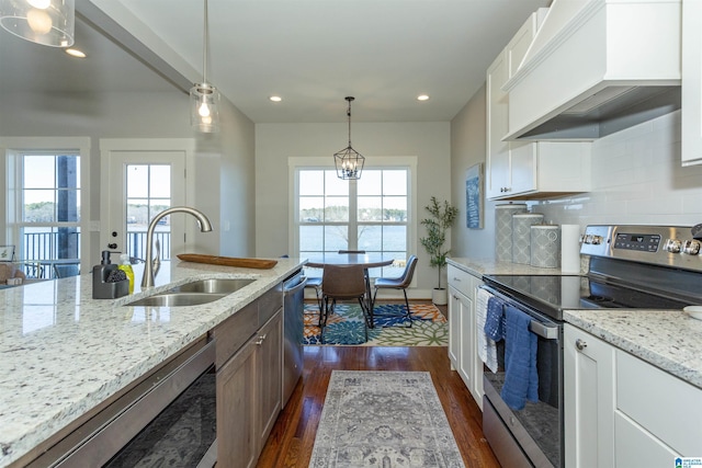 kitchen with appliances with stainless steel finishes, tasteful backsplash, white cabinetry, sink, and custom range hood