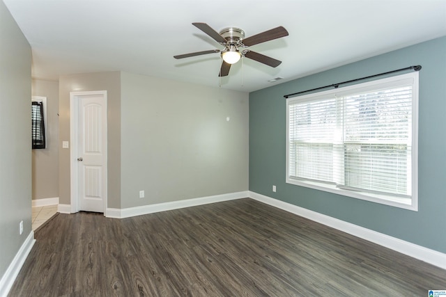 empty room with ceiling fan and dark hardwood / wood-style flooring