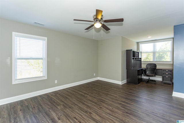 unfurnished office with ceiling fan and dark hardwood / wood-style flooring